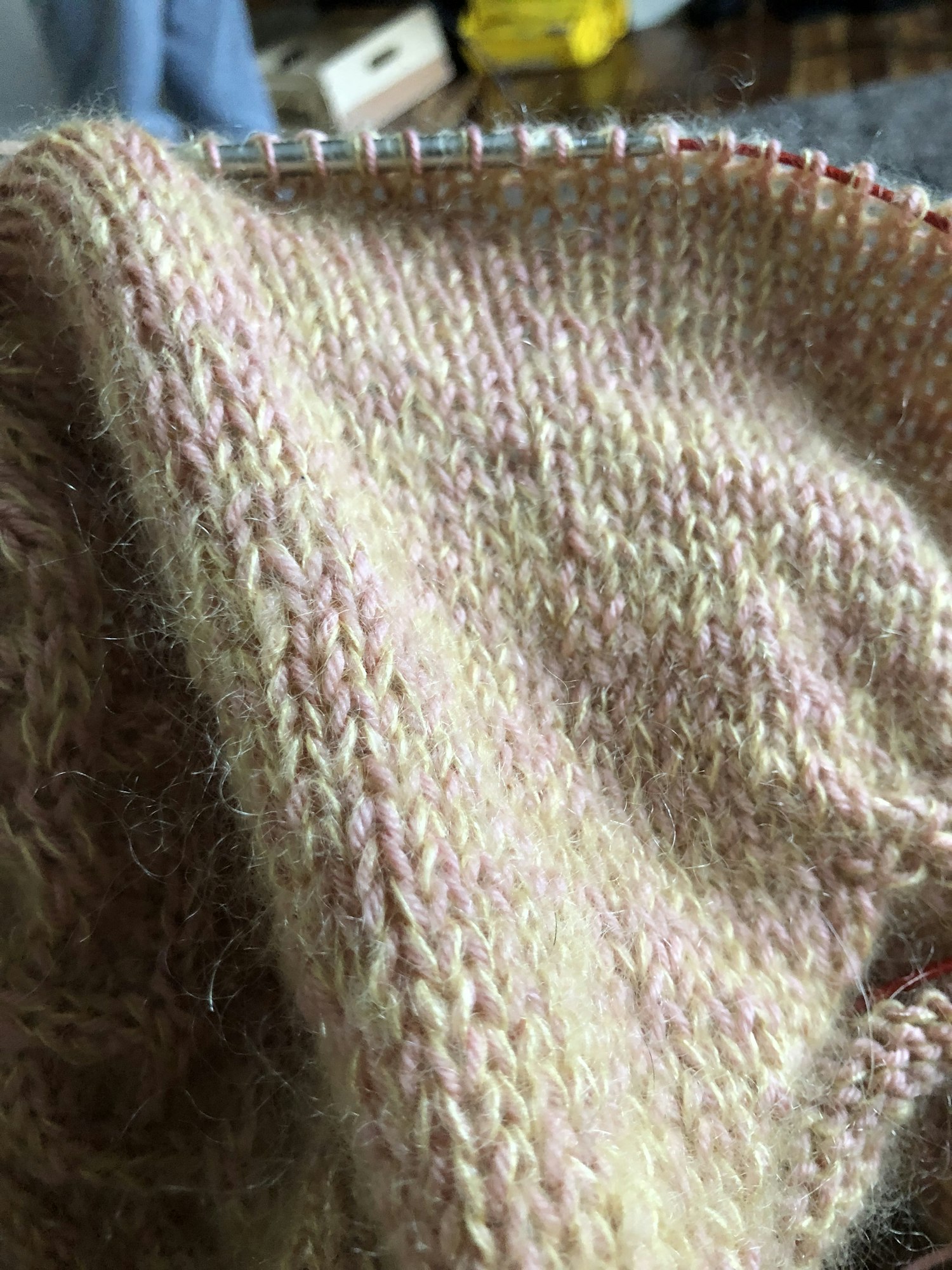 Close up photo of the knit with yellow mohair and pink wool fingering yarn.